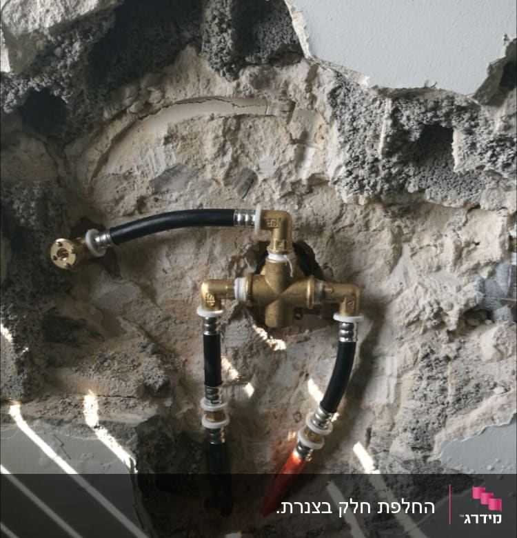 צנרת מים חשופה בקיר עם מחברים